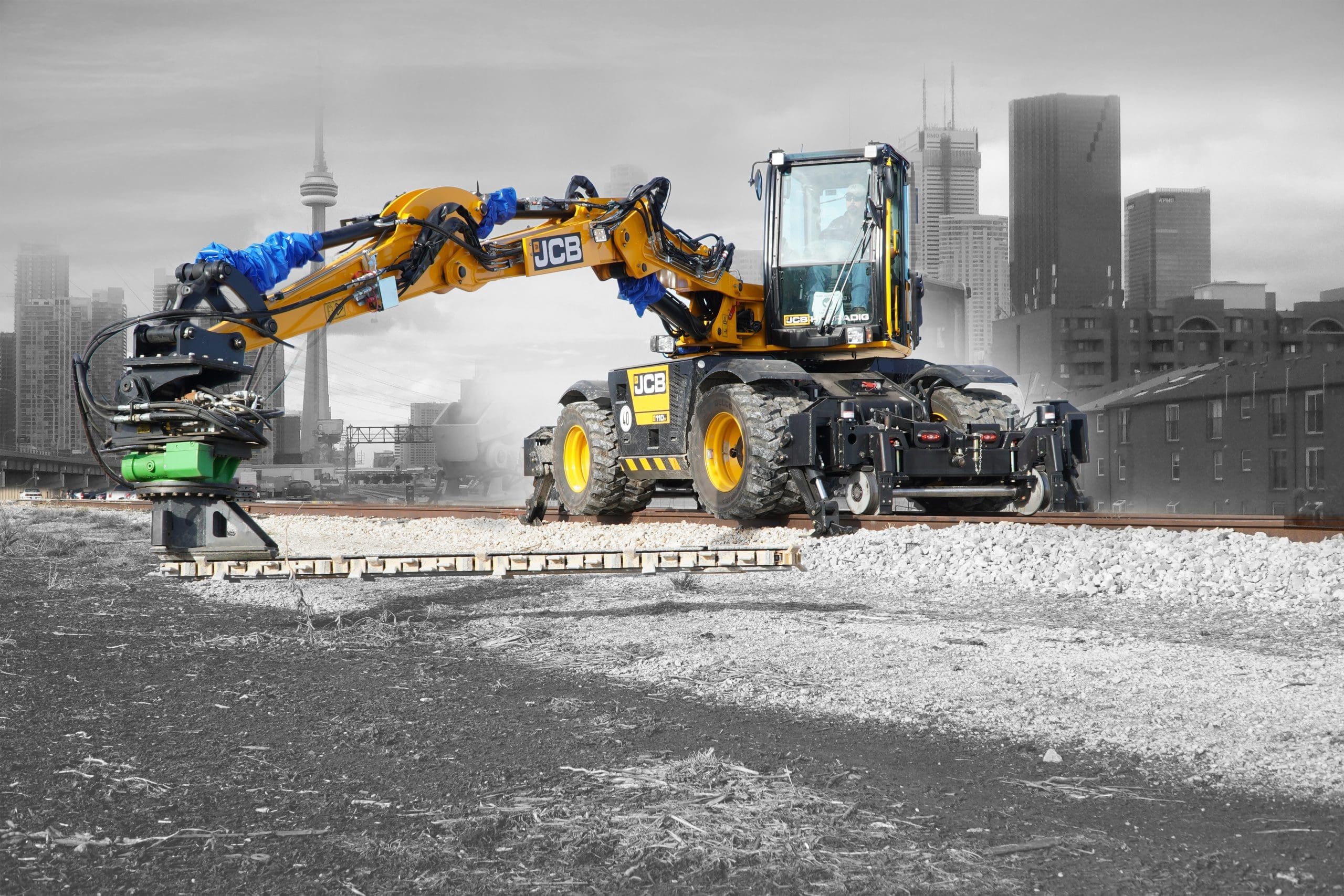 DymaxRail Ballast Blaster on JCB Hydradig Hi-Rail Excavator DymaxRail Ballast Blaster undercutter mounted on JCB Hydradig hi-rail excavator performing railway track maintenance