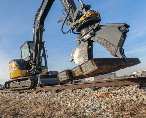 DymaxRail Hydraulic Clam Cribbing Bucket on compact excavator repositioning rail ties at track maintenance job site