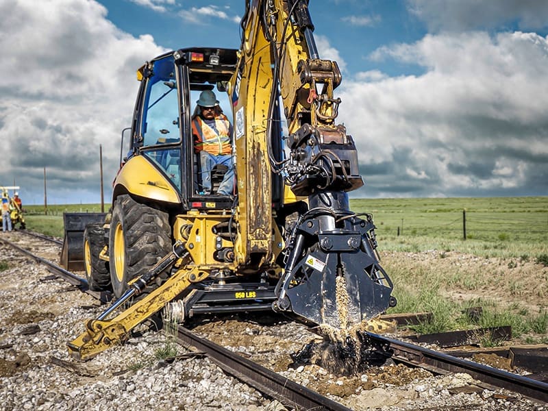 Click to show details - DymaxRail Hydraulic Clam Cribbing Bucket on Backhoe Hi-Rail DymaxRail Hydraulic Clam Cribbing Bucket mounted on backhoe Rail Rider hi-rail system