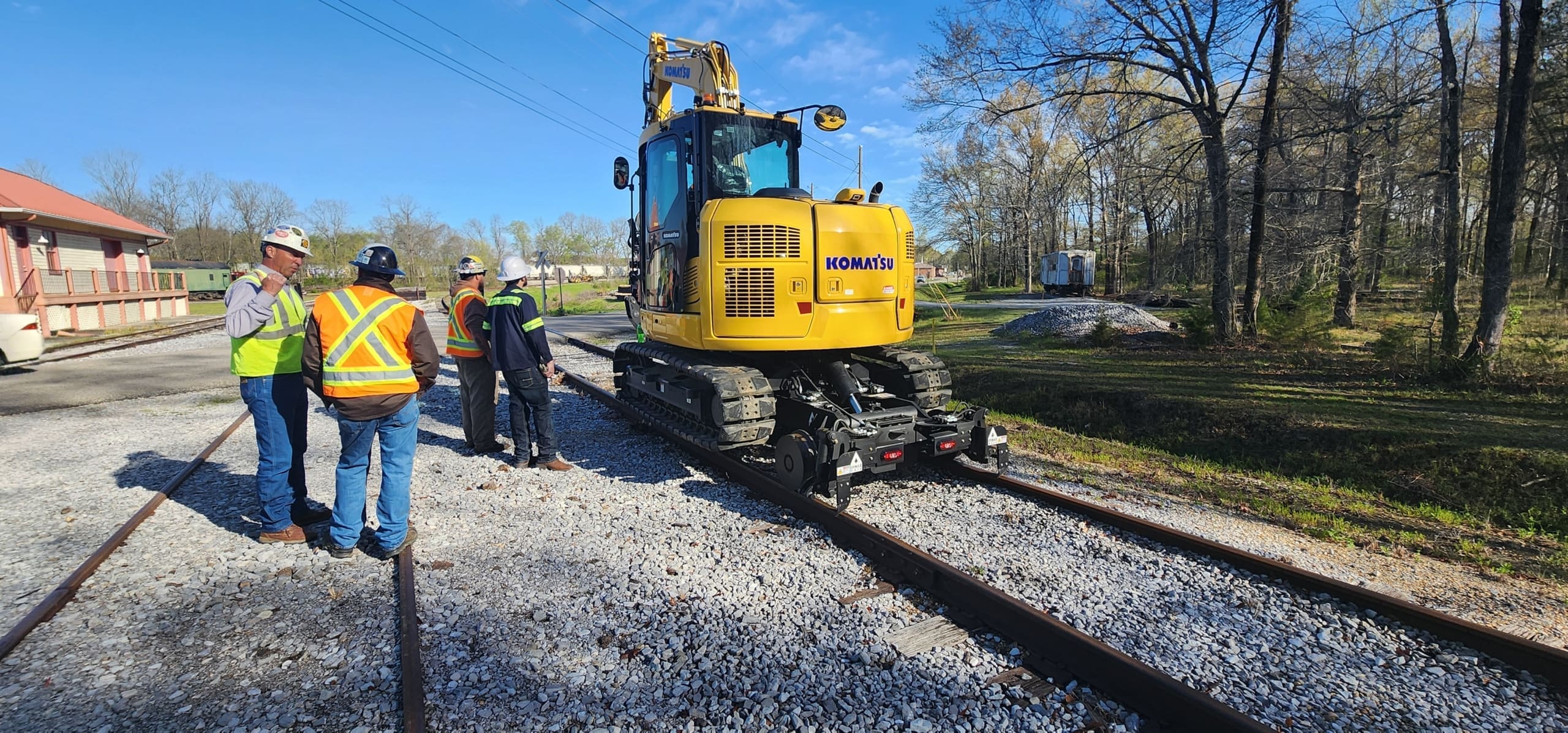 SDAC Rail crew with Tractor & Equipment Company and DymaxRail reviewing the hi-rail excavator setup at Heart of Dixie Railroad.