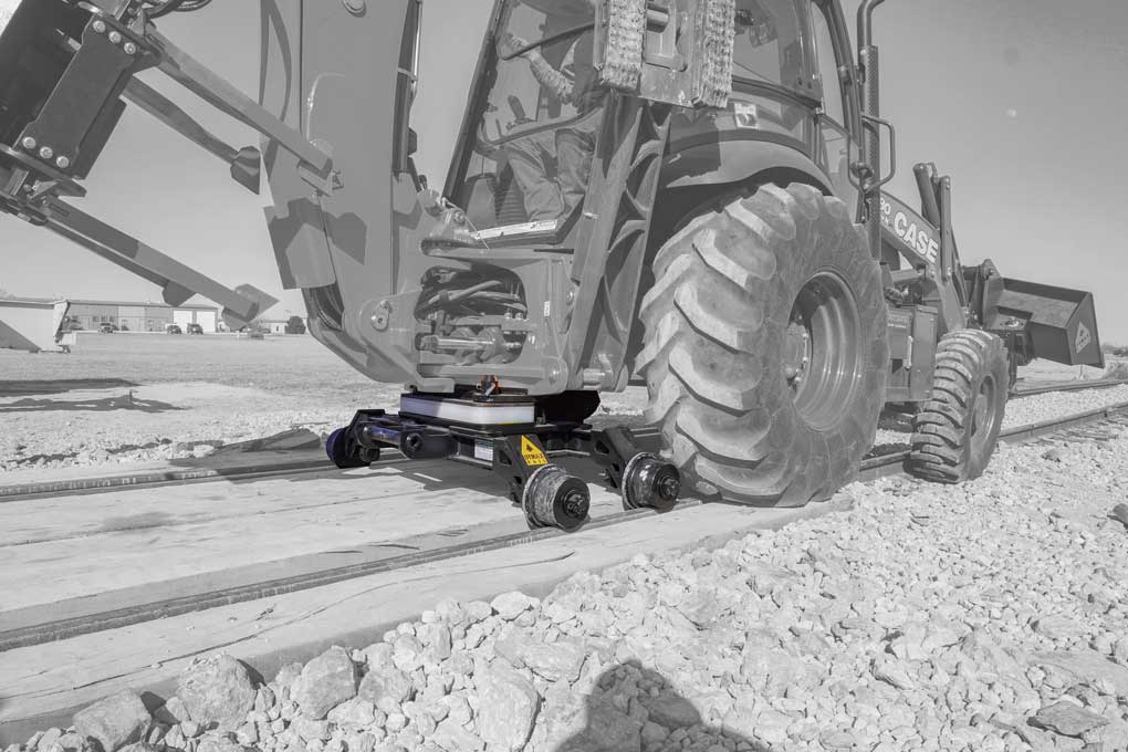 Case backhoe loader equipped with the Dymax Rail Rider hi-rail guide system on rail