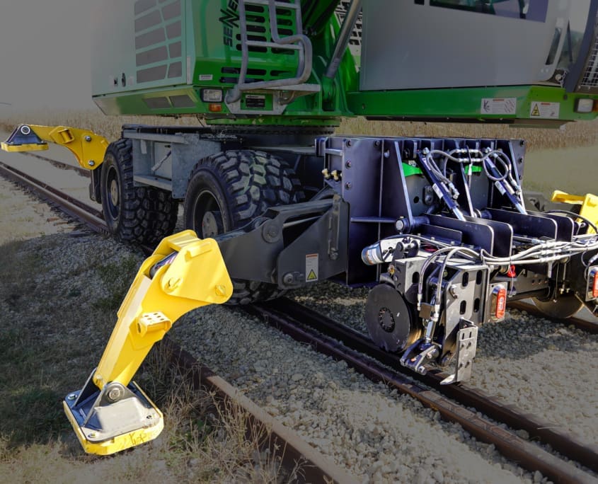 DymaxRail Rail Rider WX4S hi-rail system on wheel excavator with all four stabilizers extended on rail
