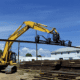 DymaxRail Rail Handler LG mounted on Komatsu excavator grabbing rail from storage pile