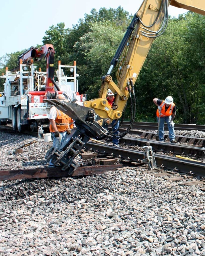 Click to show details - DymaxRail Tie Inserter – Rail Tie Replacement Attachment DymaxRail Tie Inserter attachment replacing rail ties on active track
