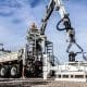 DymaxRail Rail Handler SG360 mounted on grapple truck with boom raised at rail yard