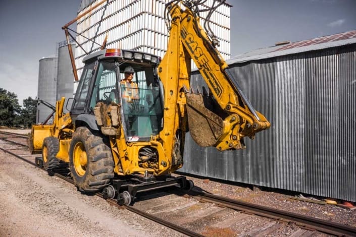 dymax-rail-rider-backhoe-loader-detachable-hi-rail-attachment Backhoe loader with detachable Dymax Rail Rider hi-rail attachment installed