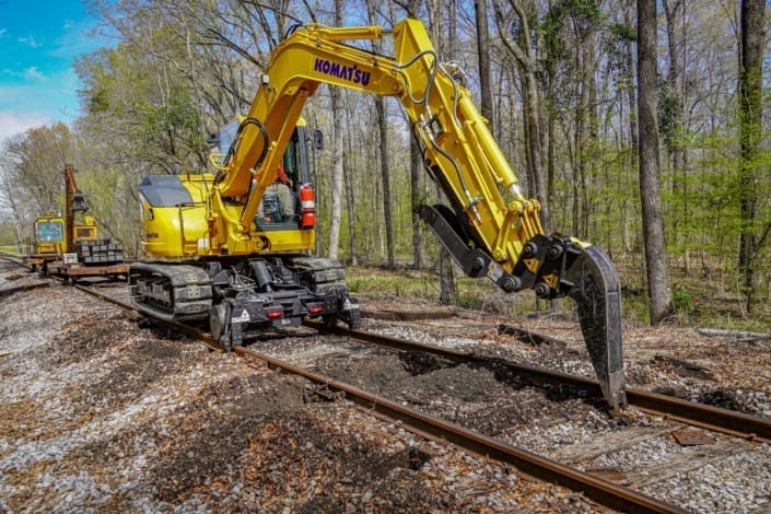 dymax-rail-rider-track-excavator-hi-rail-remote-rail-maintenance Track excavator with Dymax Rail Rider hi-rail system operating in remote rail maintenance environment